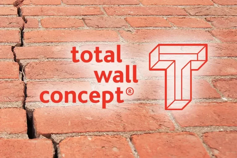 Total Wall Logo met een stenen wand achtergrond.