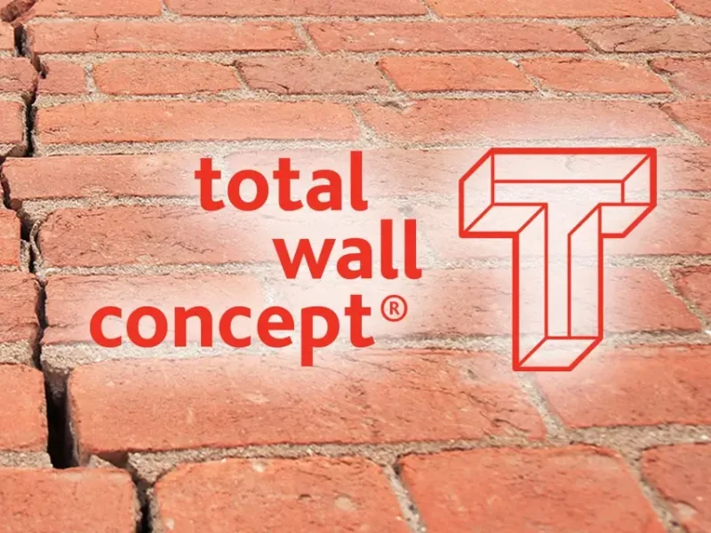 Total Wall Logo met een stenen wand achtergrond.