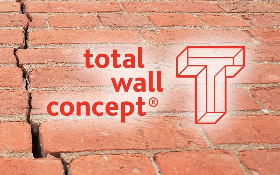 Total Wall Logo met een stenen wand achtergrond.