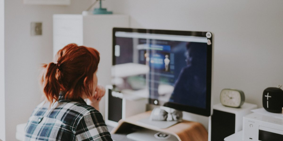 Een vrouw kijkt naar een computer scherm