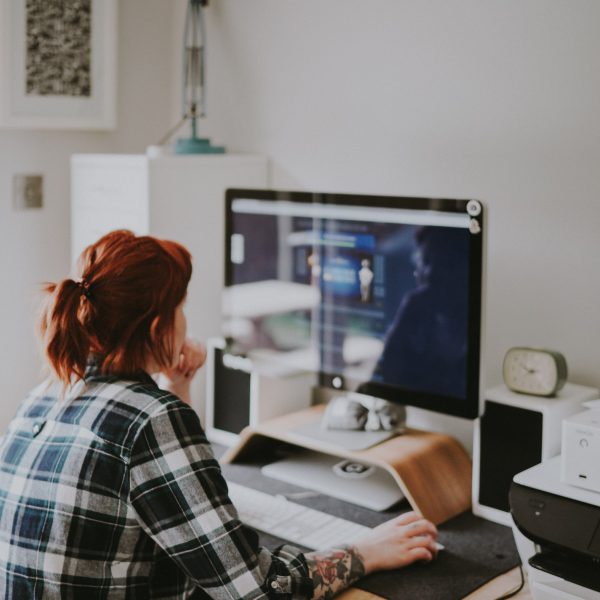Een vrouw kijkt naar een computer scherm