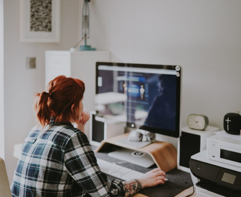 Een vrouw kijkt naar een computer scherm