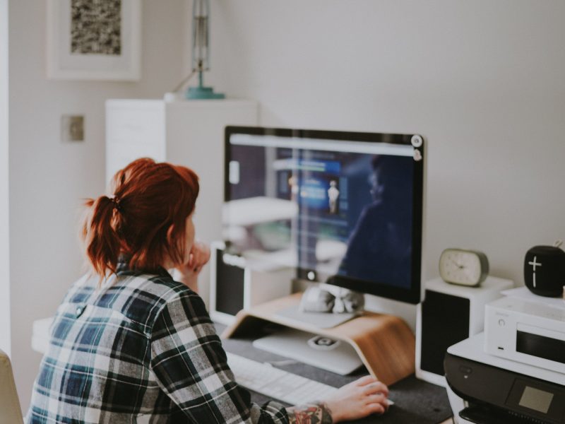 Een vrouw kijkt naar een computer scherm