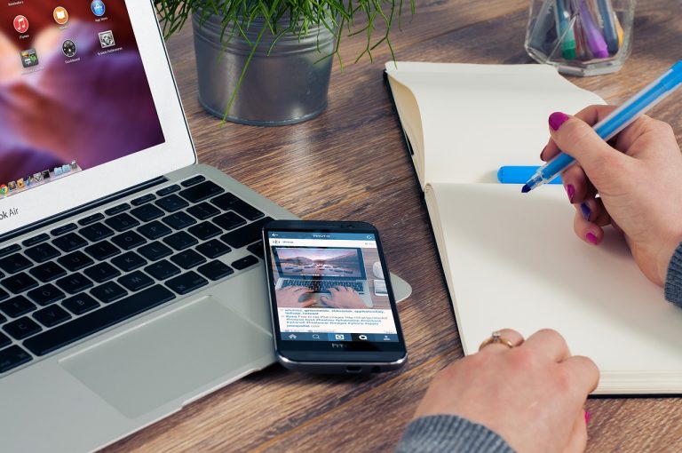 Laptop, telefoon en kladblok