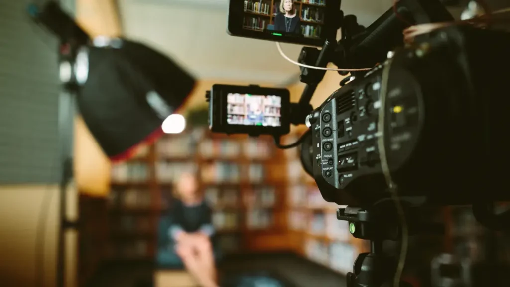 Een videocamera staat opgesteld voor een boekenkast. Perfect voor het vastleggen van videocontent.