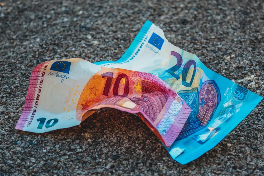 Twee eurobiljetten van 10 en 20 euro liggen op de grond.